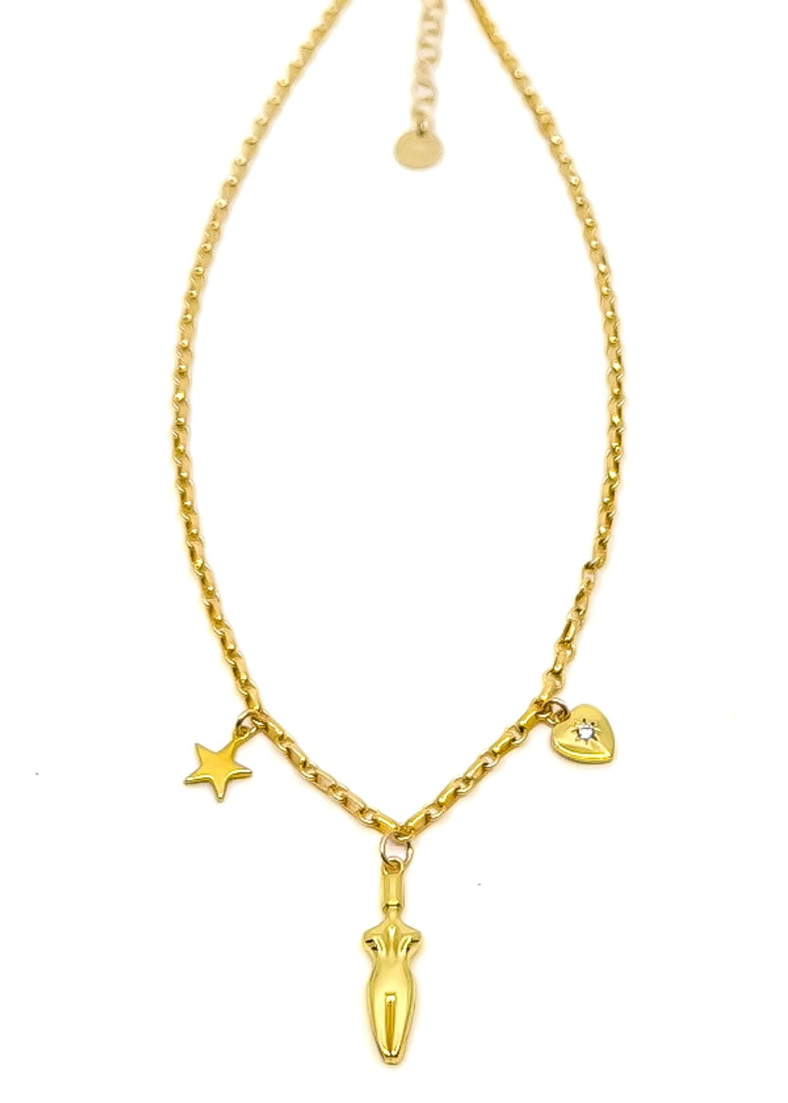 A close-up of a 3 charm gold-filled necklace on a white surface. Necklace has a star, body, and a cubic zirconia heart charm.